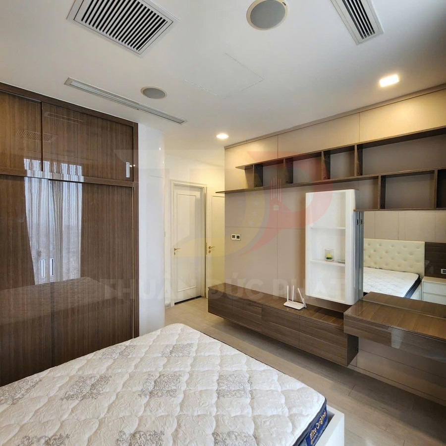 Phòng ngủ hiện đại với giường nệm lò xo và tủ quần áo gỗ âm tường màu nâu sáng