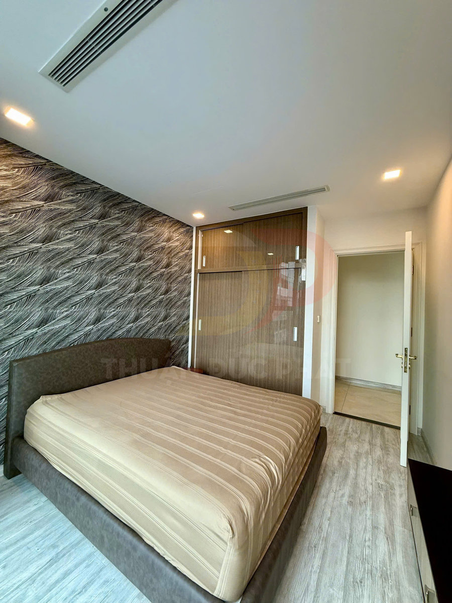 Phòng ngủ hiện đại với giường bọc nệm màu be và tủ quần áo cửa kính gỗ sát tường