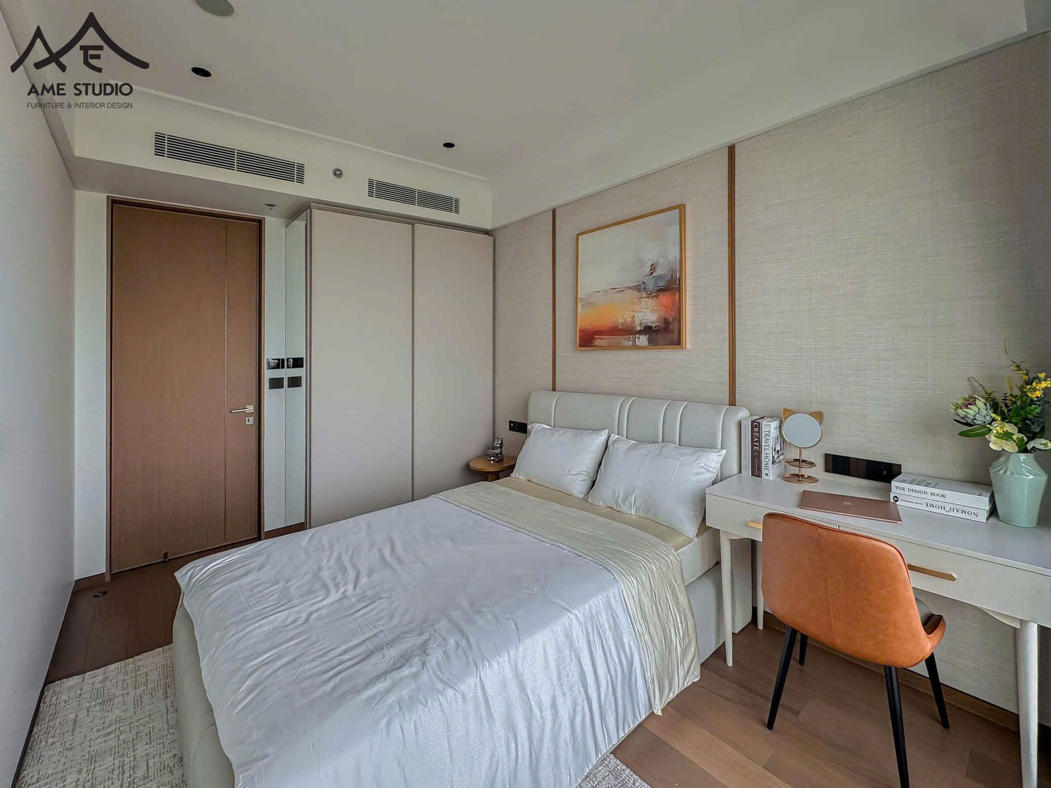 Phòng ngủ hiện đại với giường bọc da trắng, bàn làm việc nhỏ và ghế da cam cạnh bình hoa trang trí