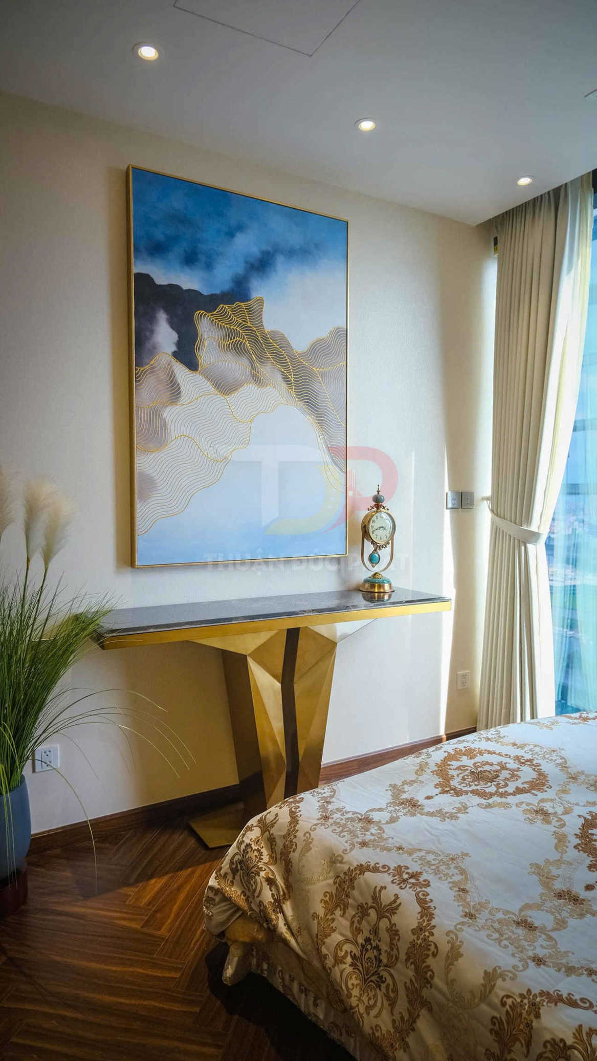 Phòng ngủ sang trọng với tranh treo tường trừu tượng, bàn console chân vàng và đồng hồ trang trí cổ điển