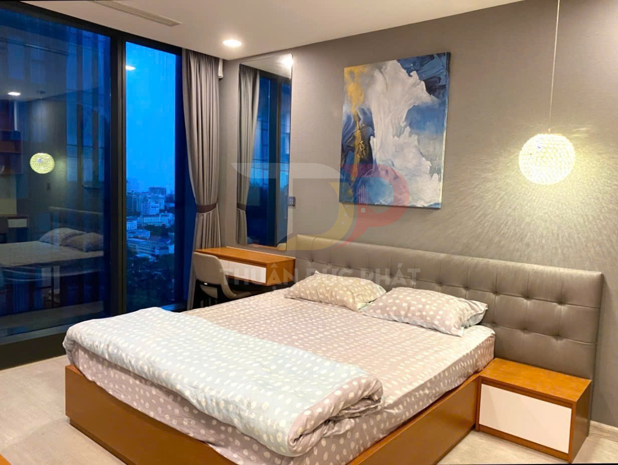 Phòng ngủ hiện đại với giường đôi bọc nệm, bộ chăn ga chấm bi và bàn làm việc cạnh cửa kính lớn