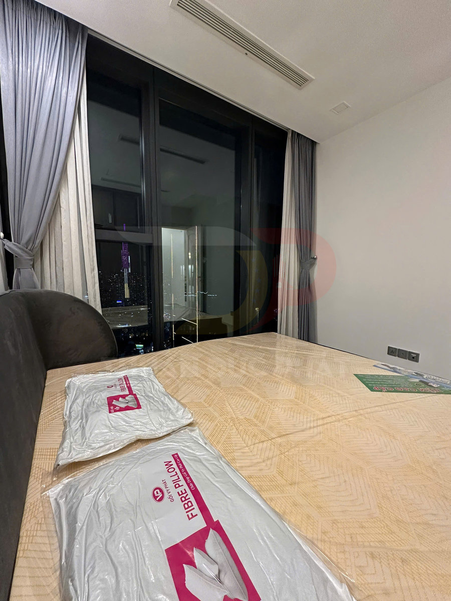 Gối sợi Fibre Pillow còn nguyên bao bì đặt trên nệm mới trong phòng ngủ có cửa kính lớn nhìn ra thành phố