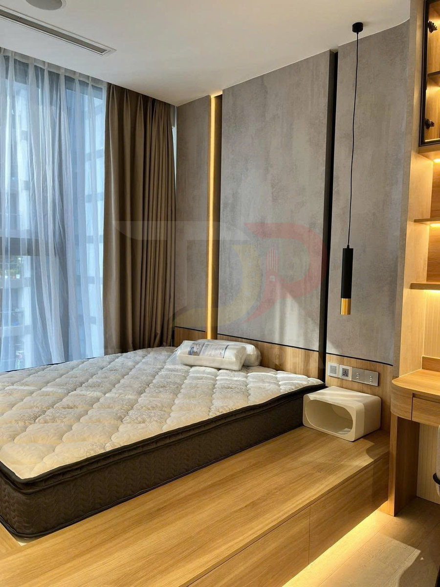 Nệm lò xo dày màu kem đặt trên bục gỗ trong phòng ngủ hiện đại có rèm cửa lớn