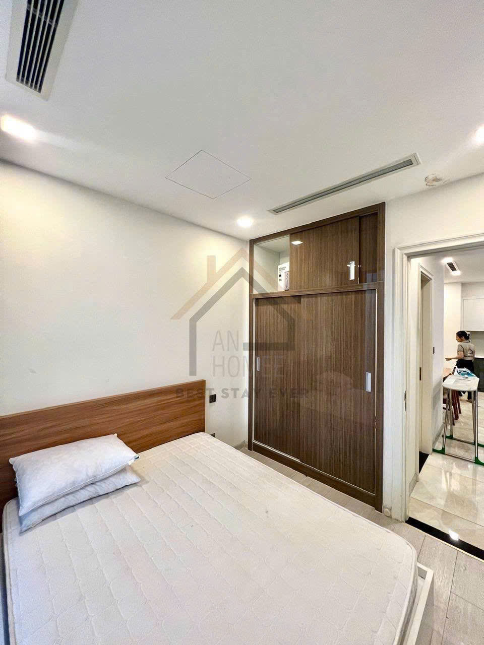 Phòng ngủ nhỏ với giường nệm trắng và tủ quần áo gỗ cửa trượt hiện đại