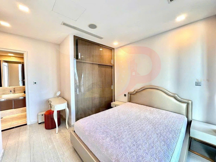 Phòng ngủ hiện đại với giường đôi bọc da, tủ quần áo gỗ cửa trượt và bàn trang điểm nhỏ cạnh cửa phòng tắm