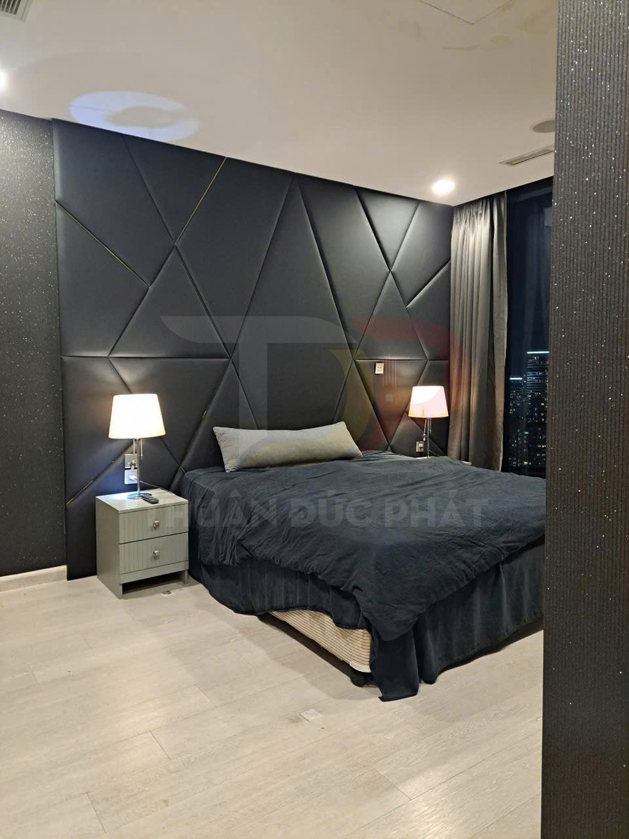 Phòng ngủ hiện đại với giường đôi bọc nệm màu đen và vách ốp da đầu giường họa tiết hình học