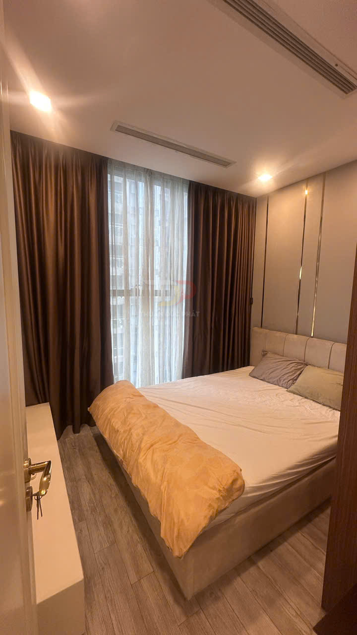 Giường ngủ đôi bọc nệm với chăn màu be trong phòng ngủ hiện đại có rèm cửa sổ lớn màu nâu
