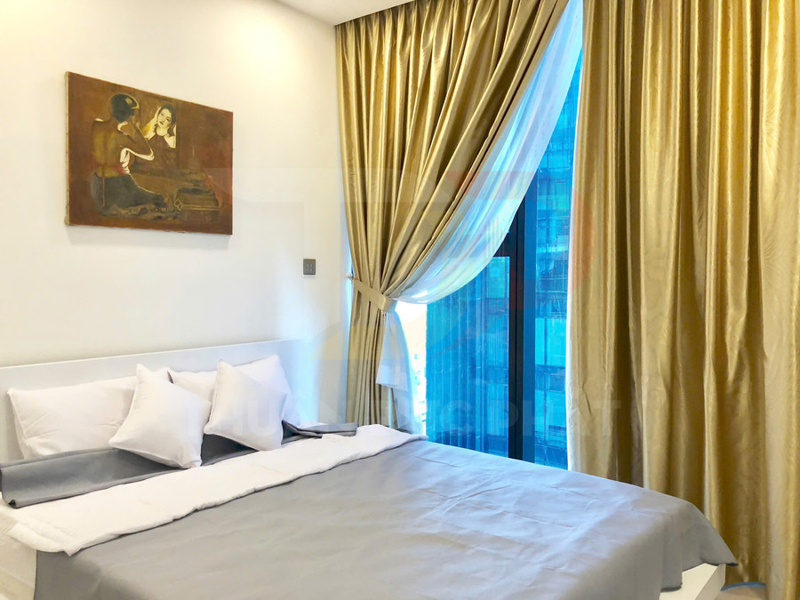Phòng ngủ hiện đại với giường đôi trải ga xám trắng, gối trắng và rèm cửa màu vàng ánh kim cạnh cửa sổ lớn