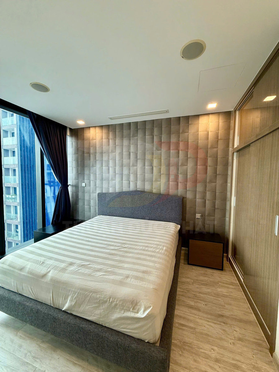 Giường ngủ đôi hiện đại với ga trắng trong phòng ngủ sáng, tường ốp nệm và cửa sổ kính lớn