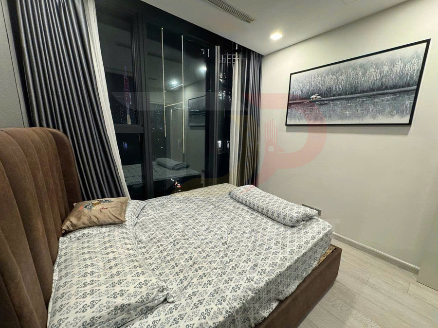 Phòng ngủ hiện đại với giường bọc nệm nâu, ga trải giường hoa văn và cửa kính lớn nhìn ra ban đêm