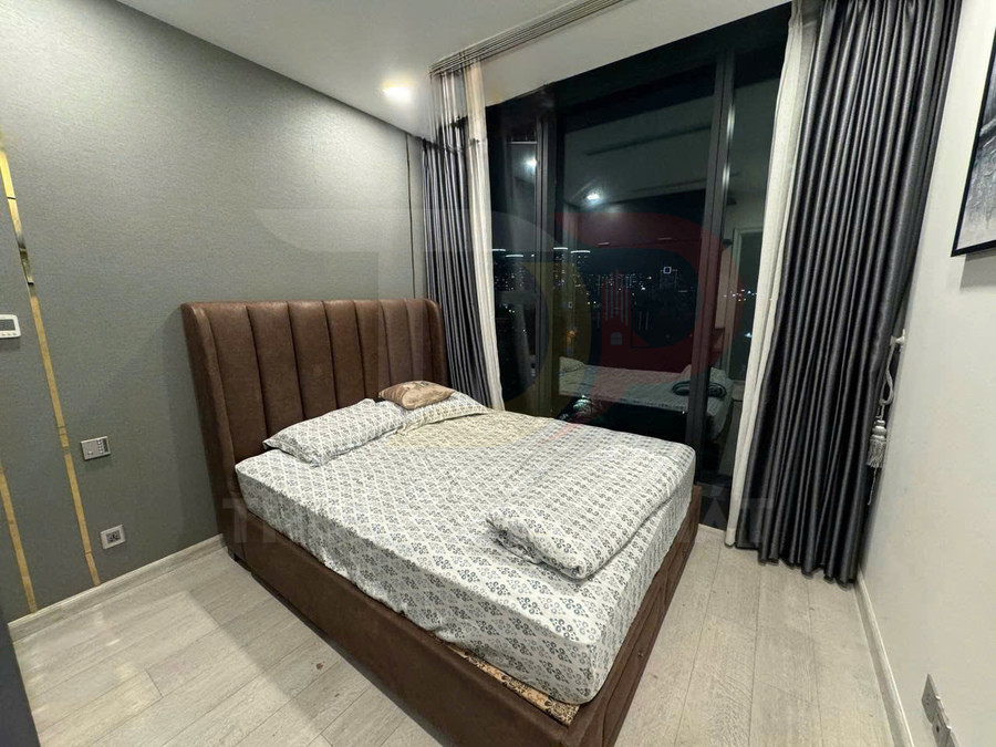 Giường ngủ bọc da màu nâu với nệm và ga trải giường hoa văn trong phòng ngủ hiện đại cạnh cửa kính lớn