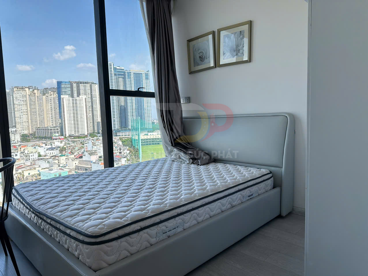 Nệm lò xo trắng trên giường bọc da hiện đại cạnh cửa sổ lớn view thành phố