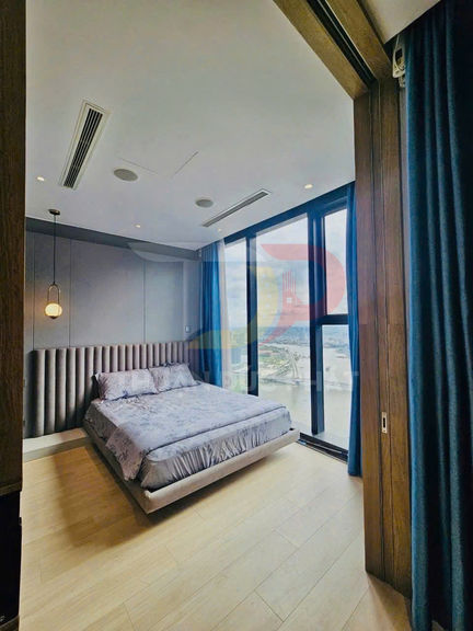 Phòng ngủ hiện đại với giường đôi bọc nệm cạnh cửa kính lớn nhìn ra cảnh thành phố