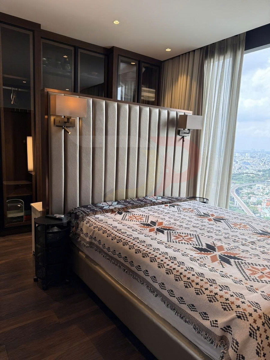 Giường ngủ bọc da với chăn họa tiết thổ cẩm trong phòng ngủ hiện đại cạnh cửa sổ kính lớn