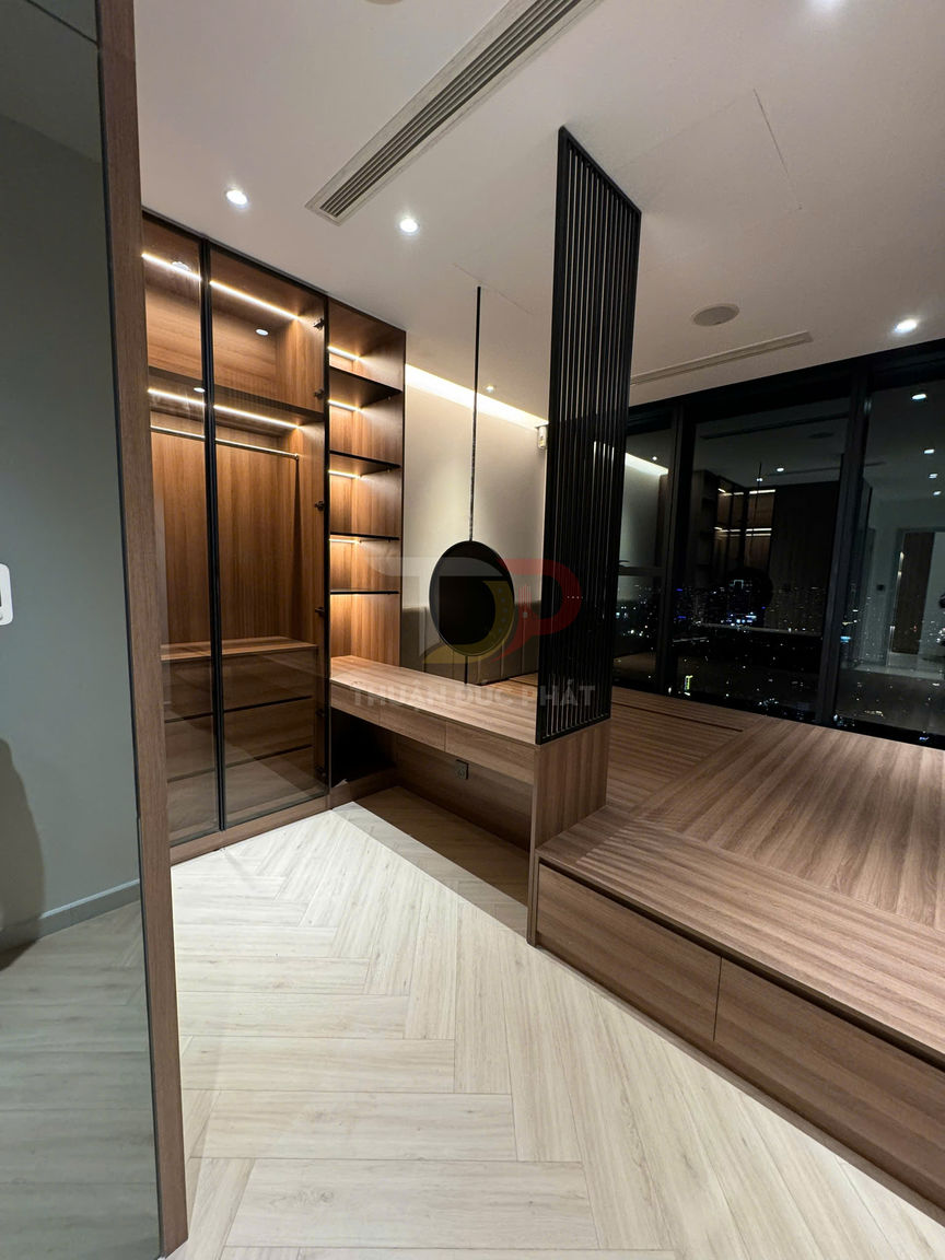 Phòng ngủ hiện đại với tủ quần áo gỗ cửa kính, giường phản gỗ liền kệ và sàn gỗ sáng màu