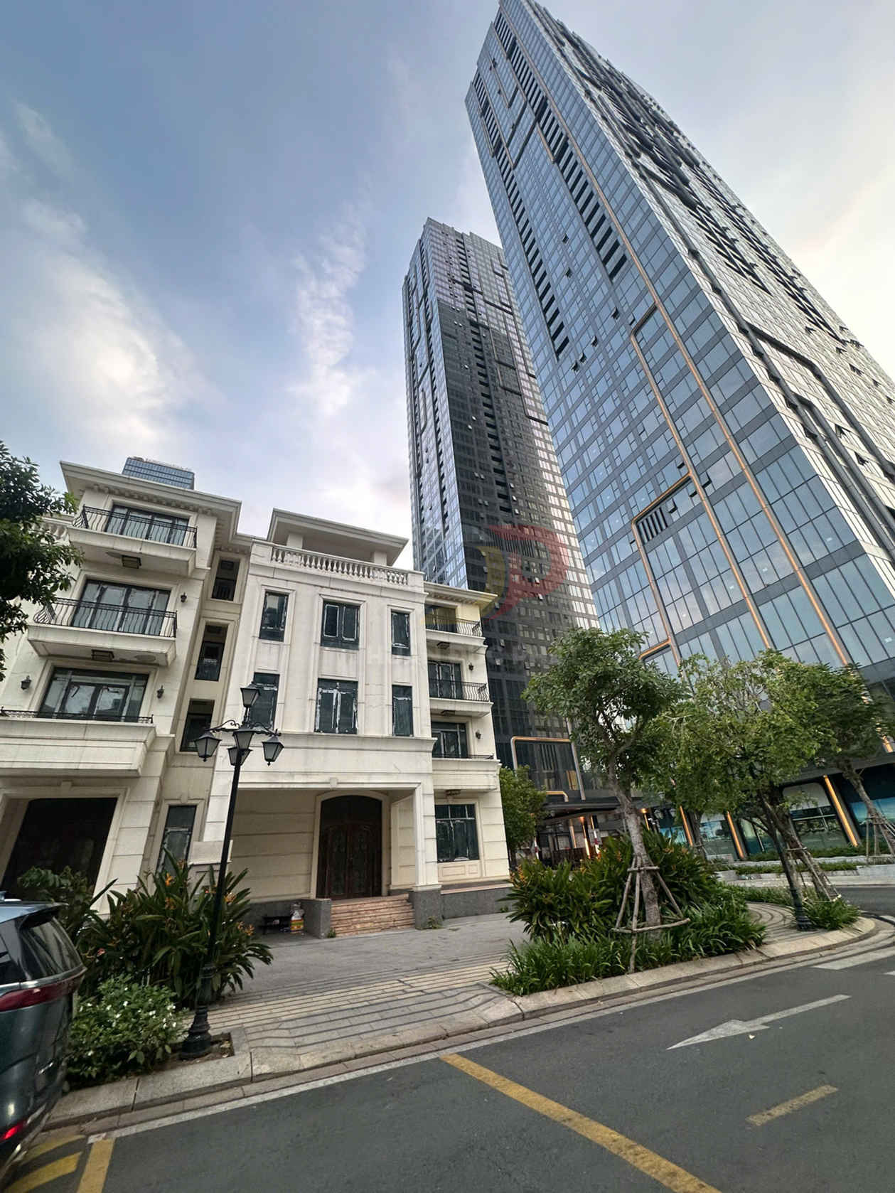 Tòa nhà văn phòng và căn hộ cao tầng hiện đại với mặt kính lớn bên cạnh biệt thự phố sang trọng