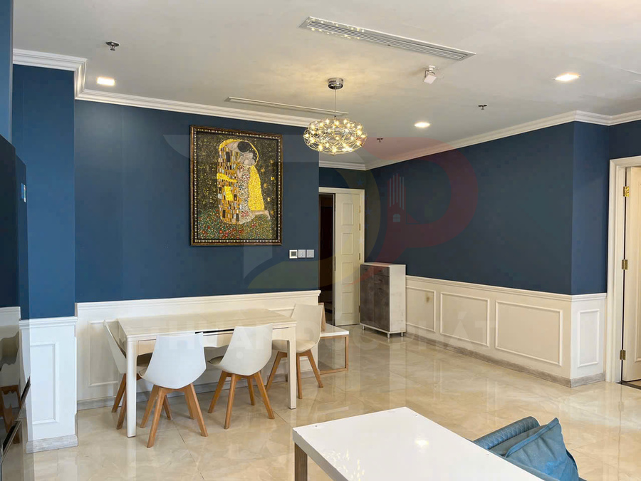 Phòng ăn hiện đại với bàn ghế gỗ trắng, tường xanh navy và đèn trần trang trí sang trọng