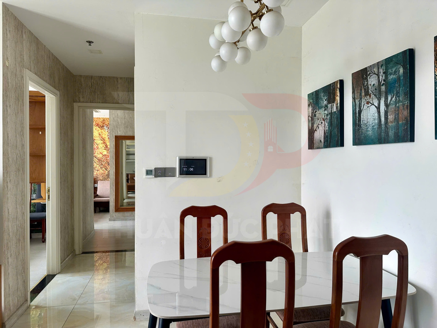 Bàn ăn mặt đá với bốn ghế gỗ trong phòng ăn hiện đại treo tranh trang trí tường
