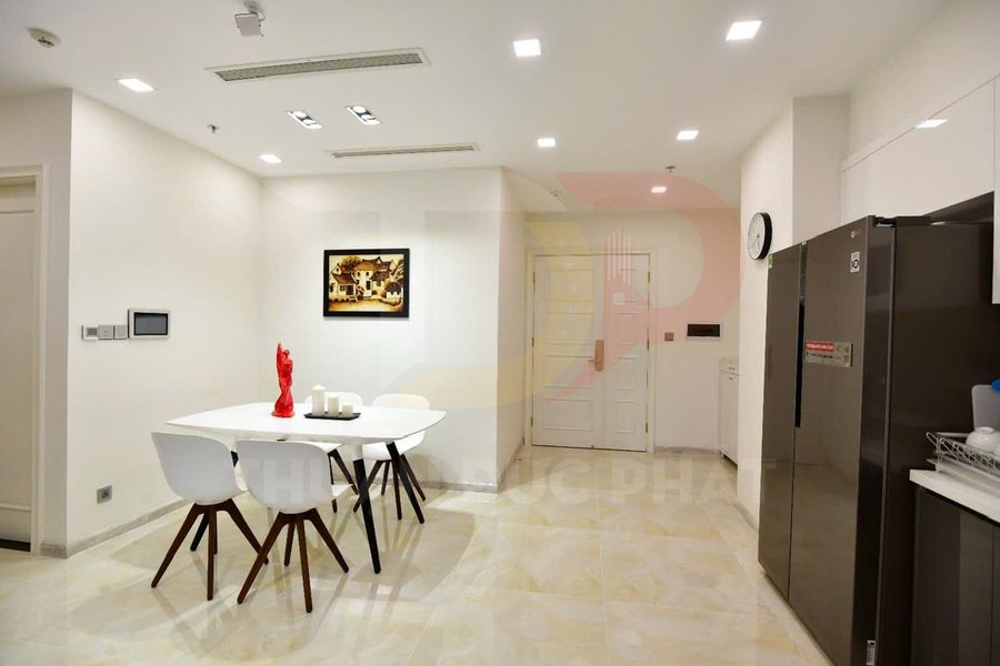 Phòng bếp hiện đại với bàn ăn trắng bốn ghế và tủ lạnh lớn màu đen