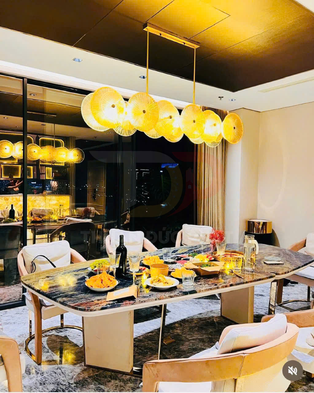 Bàn ăn đá cẩm thạch sang trọng với ghế bọc nệm và đèn thả trần vàng hiện đại trong phòng ăn cao cấp