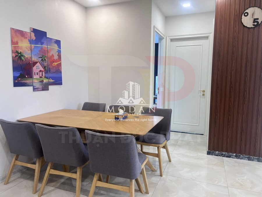 Bộ bàn ăn gỗ hình chữ nhật với sáu ghế nệm xám trong phòng ăn hiện đại sáng sủa