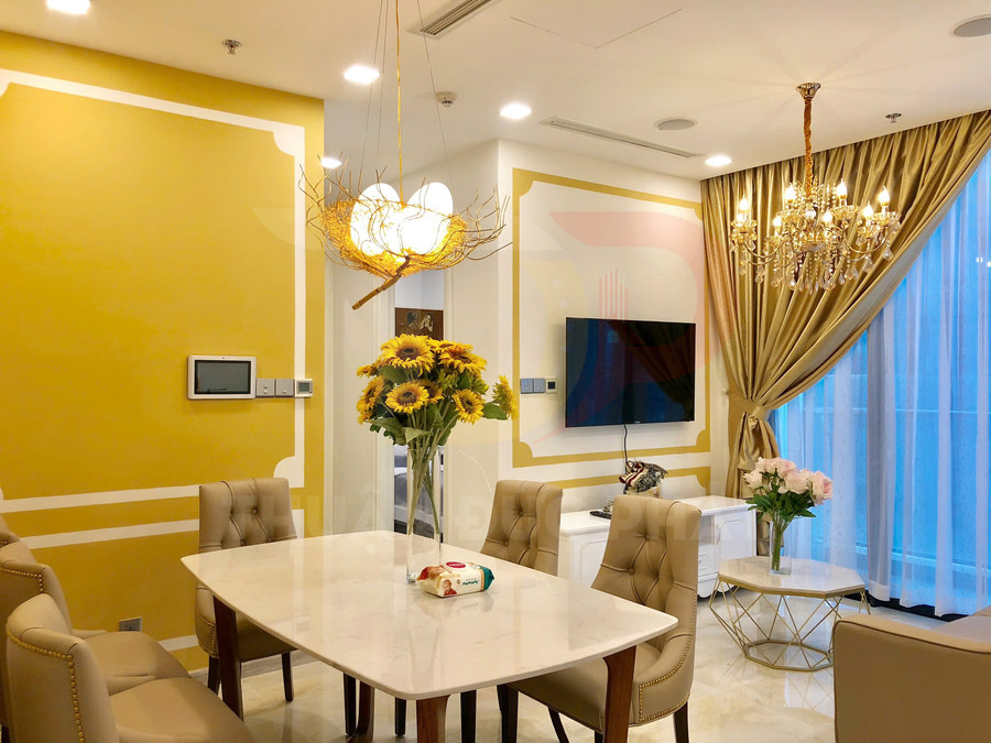 Phòng ăn sang trọng với bàn đá trắng, ghế bọc da và bình hoa hướng dương trang trí nổi bật