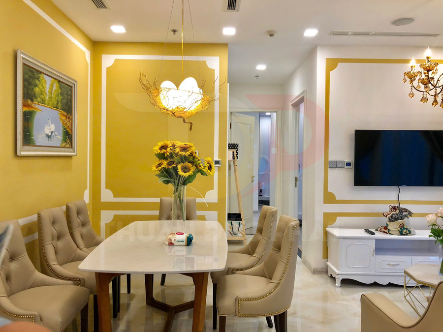 Bàn ăn mặt đá với ghế da màu be trong phòng khách vàng trắng trang trí hoa hướng dương