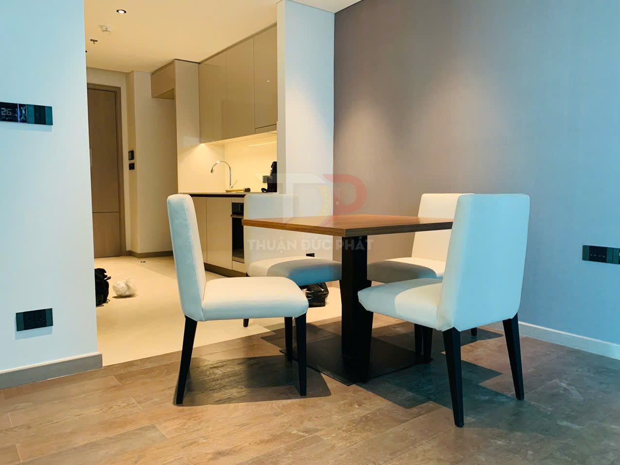 Bộ bàn ăn gỗ vuông bốn ghế bọc nệm trắng trong phòng bếp căn hộ hiện đại