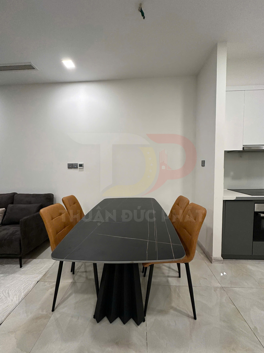 Bàn ăn mặt đá đen chân trụ hiện đại kèm bốn ghế nệm màu nâu trong phòng khách liền bếp