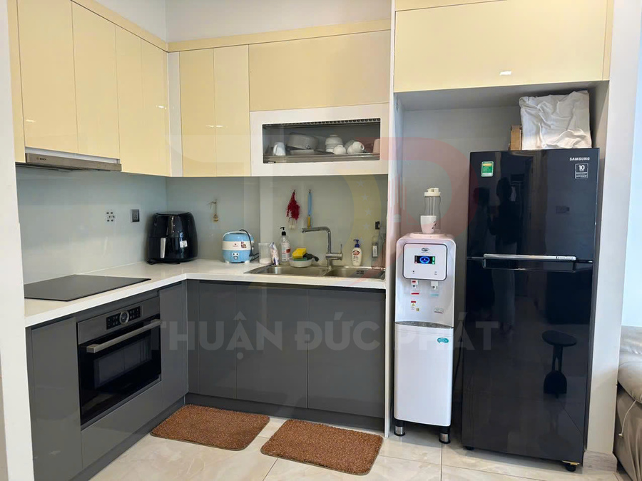 Gian bếp hiện đại với tủ bếp chữ L, tủ lạnh Samsung màu đen, lò nướng âm tủ và bếp từ