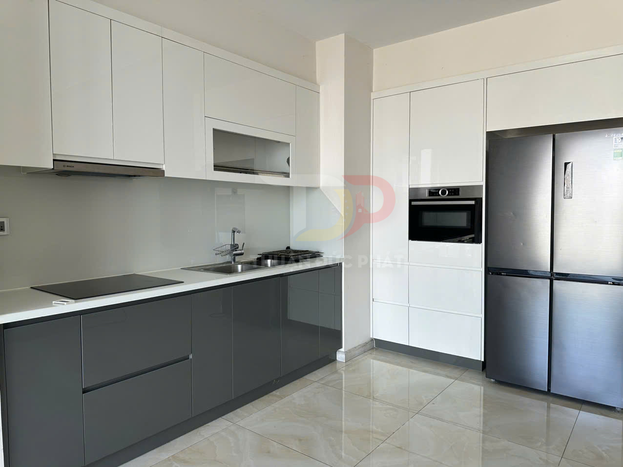 Tủ bếp chữ I hiện đại với mặt đá trắng, bếp từ, chậu rửa inox, lò nướng âm tủ và tủ lạnh lớn inox