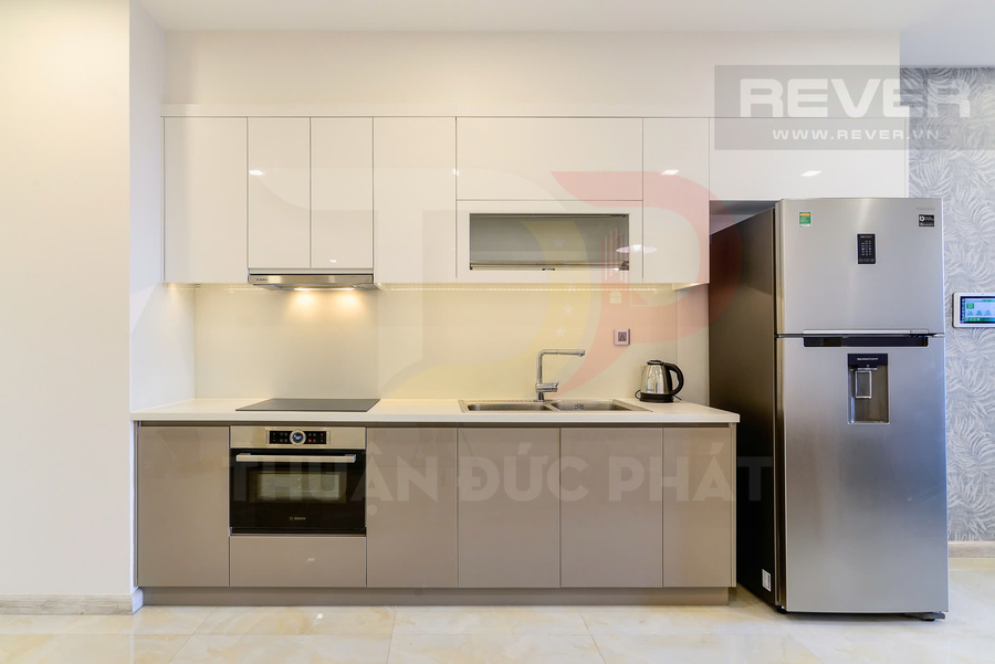Tủ bếp hiện đại với bếp từ, lò nướng Bosch, bồn rửa và tủ lạnh inox hai cửa trong căn hộ cao cấp