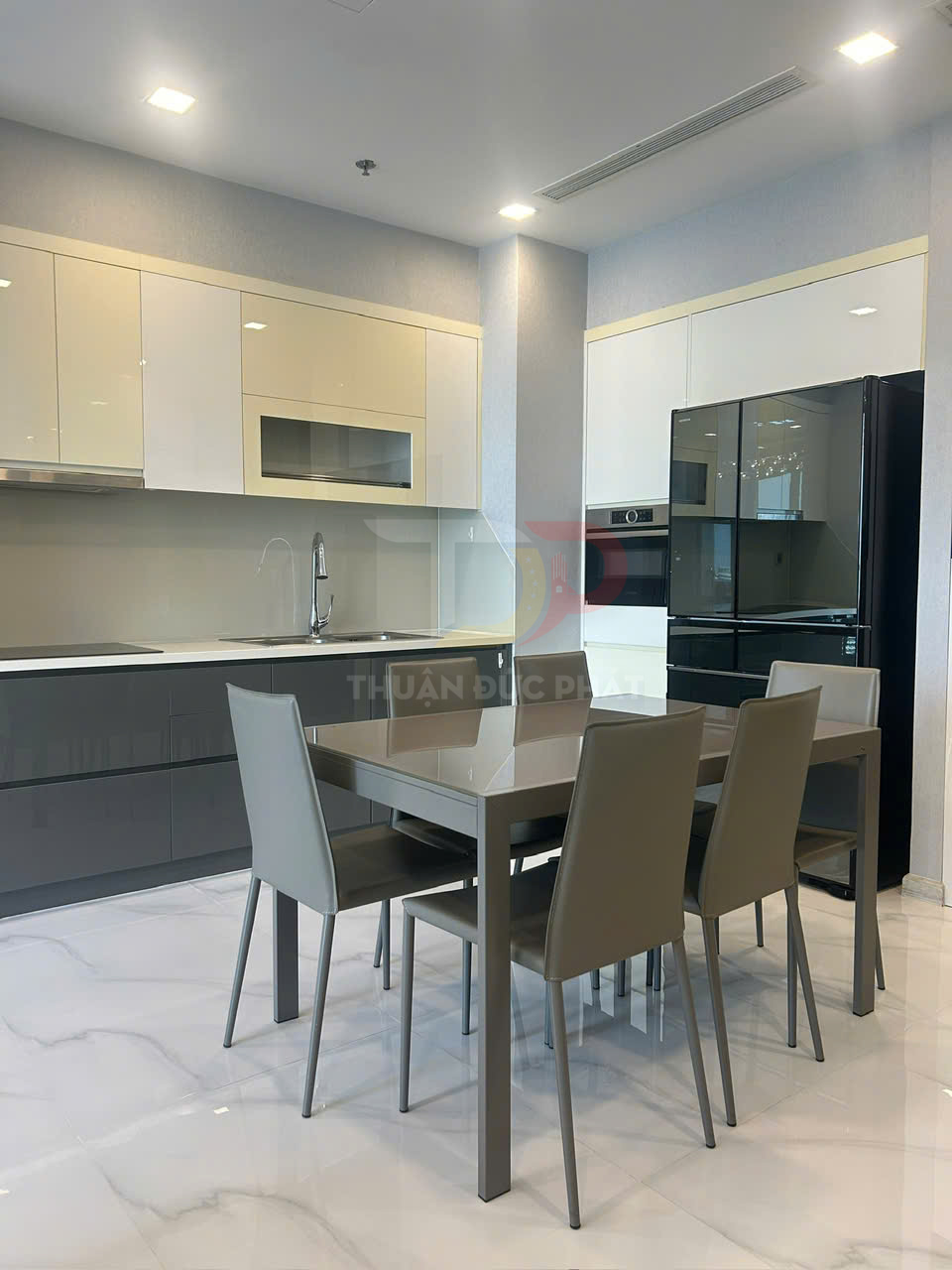 Bộ bàn ăn 4 ghế màu xám hiện đại đặt trong không gian bếp tủ bếp chữ L và tủ lạnh cao cấp