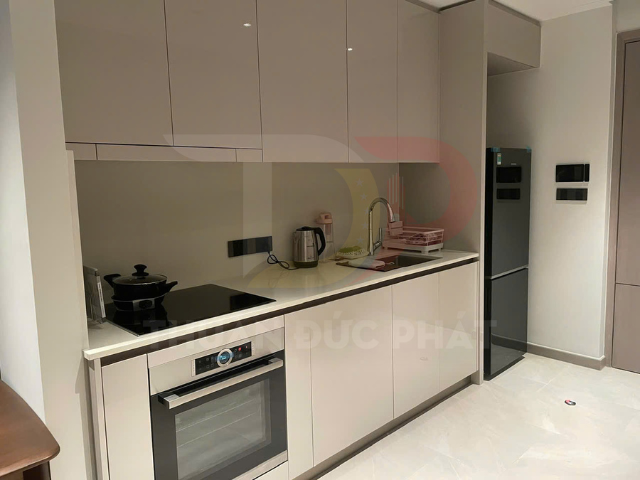 Tủ bếp hiện đại với bếp từ, lò nướng âm tủ, ấm đun nước điện và tủ lạnh hai cánh màu bạc