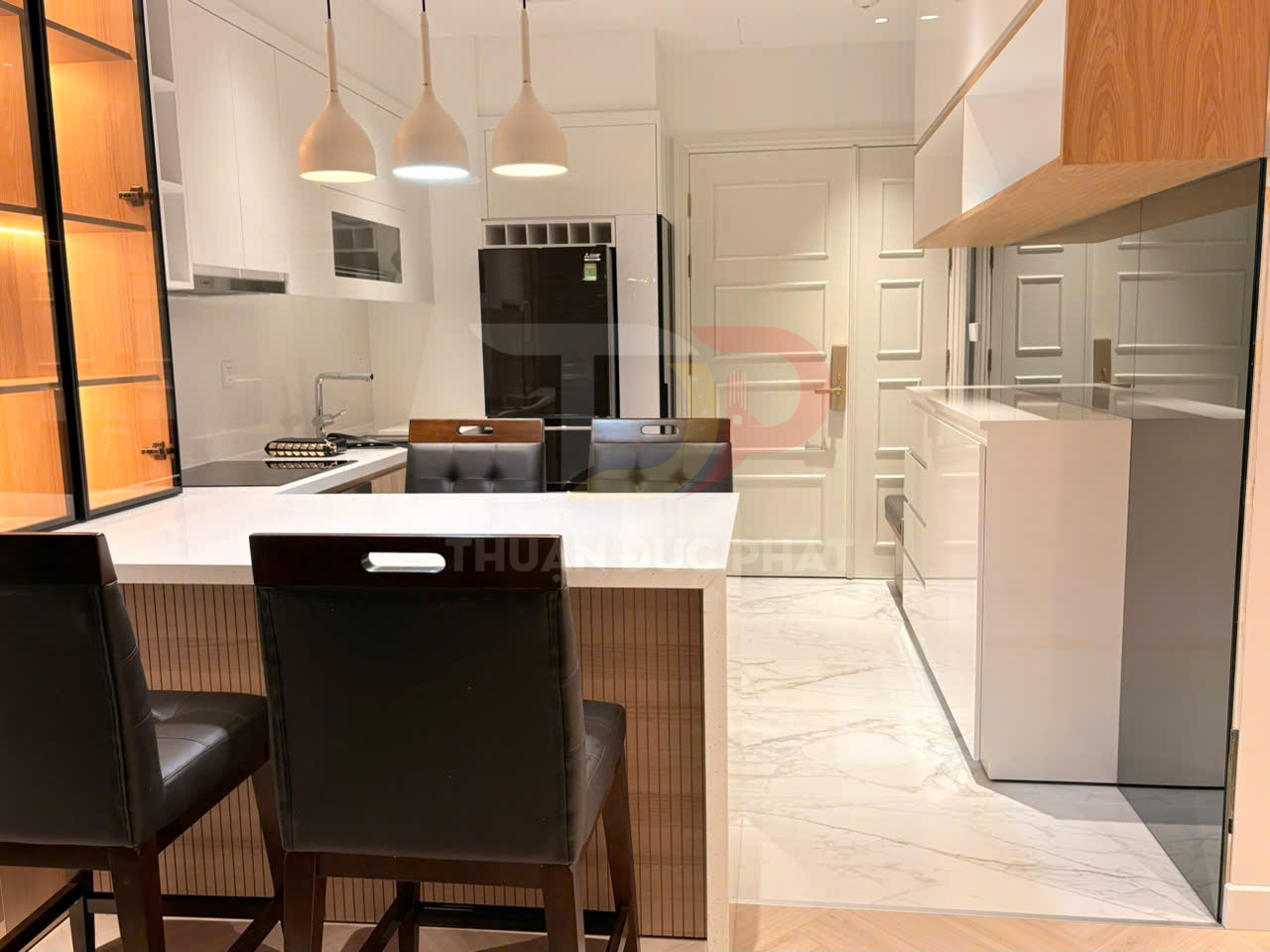 Bếp hiện đại với tủ bếp gỗ trắng, đảo bếp mặt đá và ghế da cao cấp trong không gian sang trọng