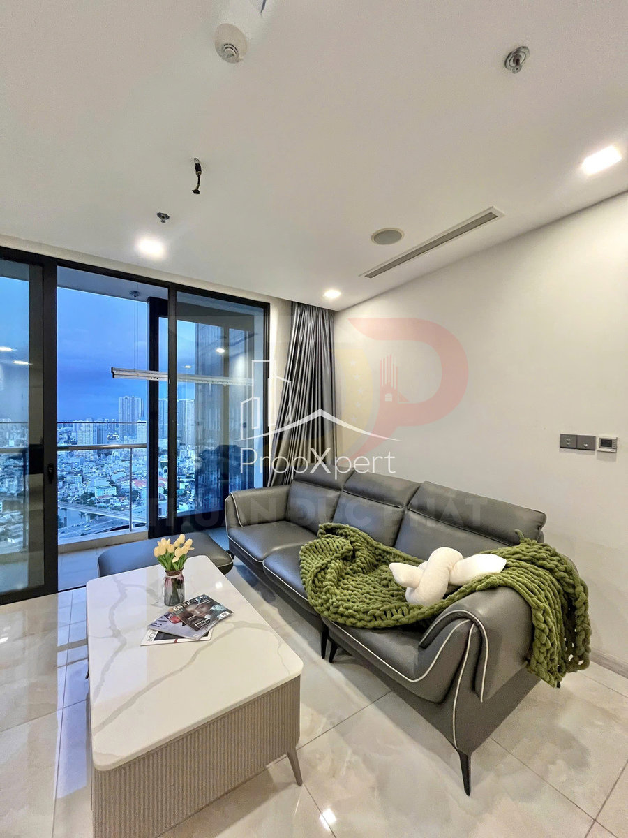 Sofa da xám trong phòng khách chung cư hiện đại với bàn trà đá và cửa kính nhìn ra thành phố
