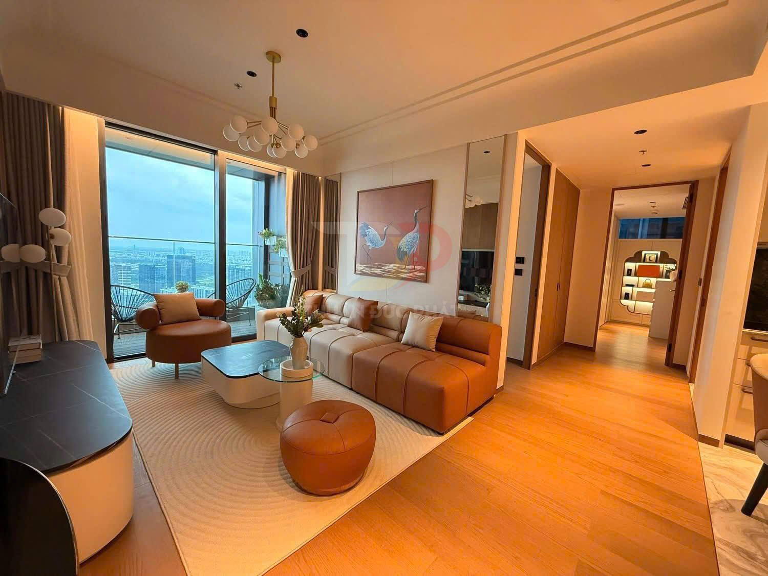 Phòng khách chung cư cao cấp với sofa da màu nâu, bàn trà hiện đại và cửa kính lớn nhìn ra ban công