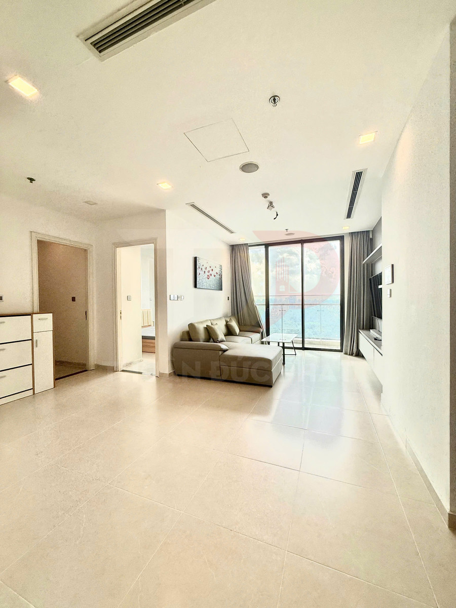 Phòng khách căn hộ hiện đại với sofa chữ L cạnh cửa kính lớn nhìn ra view sông
