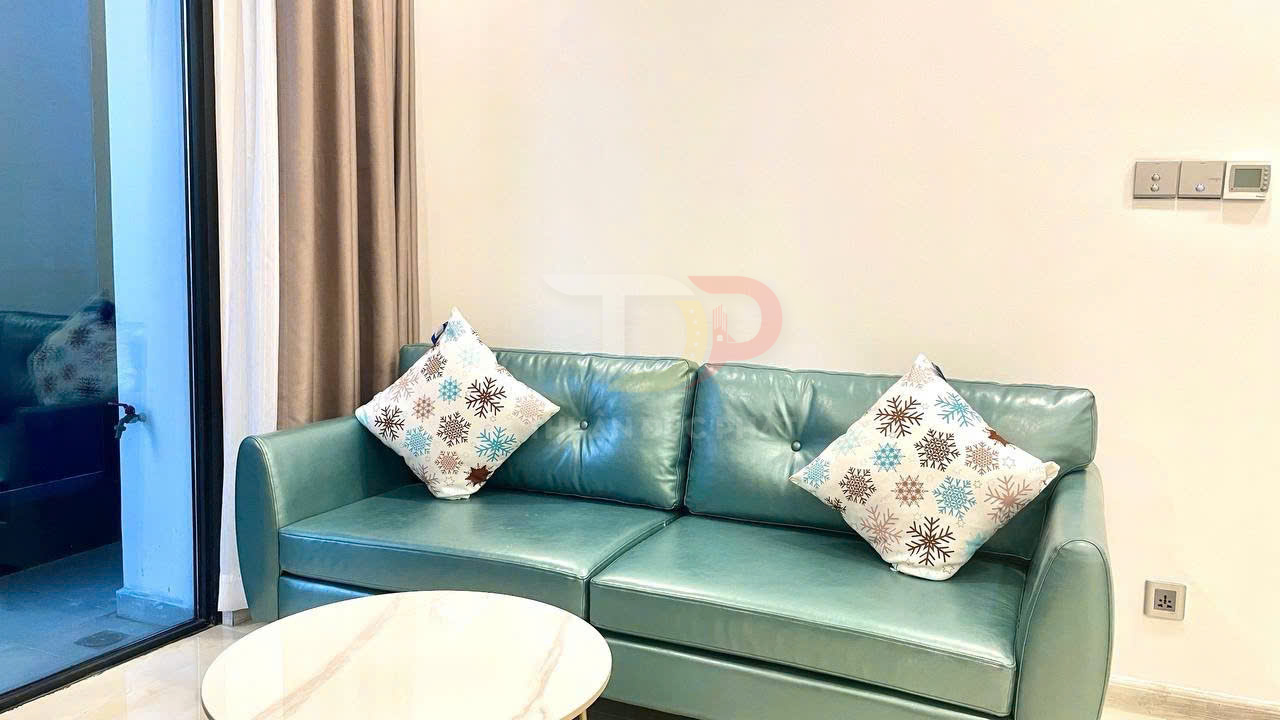 Sofa da màu xanh ngọc với hai gối tựa họa tiết bông tuyết trong phòng khách hiện đại