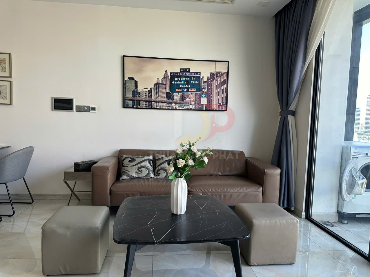 Sofa da màu nâu trong phòng khách hiện đại với bàn trà đá đen và bình hoa trang trí trên mặt bàn