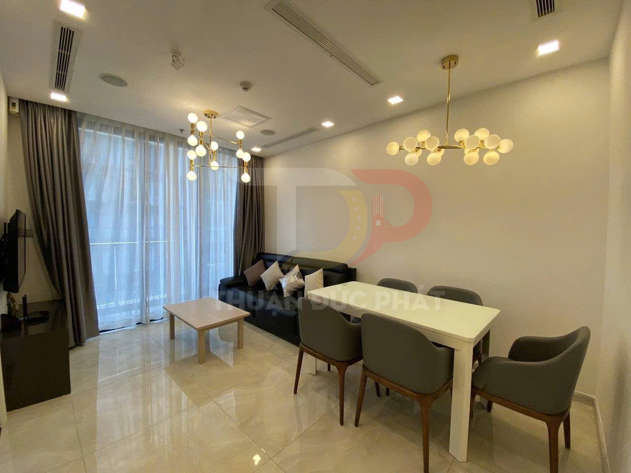 Phòng khách chung cư hiện đại với sofa da, bàn trà gỗ, bàn ăn 6 ghế và đèn trần trang trí