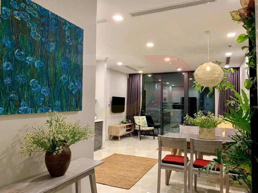 Phòng khách và bàn ăn chung cư hiện đại với nhiều cây xanh và tranh treo tường lớn tông xanh
