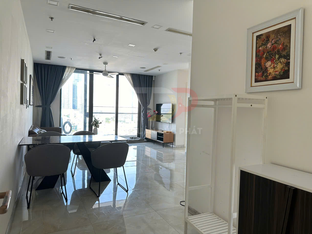 Phòng khách chung cư hiện đại với bàn ăn đá, ghế bọc nệm và cửa kính lớn nhìn ra thành phố