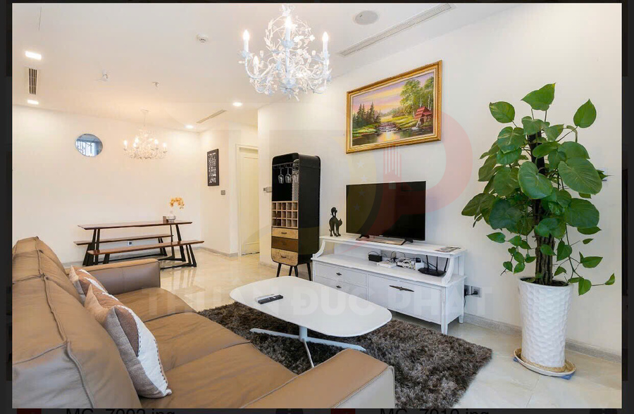 Phòng khách hiện đại với sofa da, bàn trà trắng, kệ tivi và cây xanh trang trí cạnh tivi
