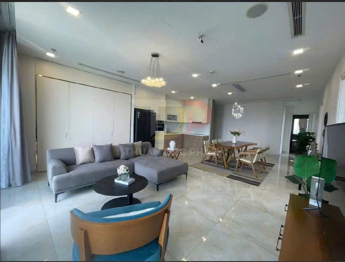 Phòng khách và phòng ăn chung cư cao cấp với sofa xám, bàn gỗ và bếp hiện đại sáng rộng