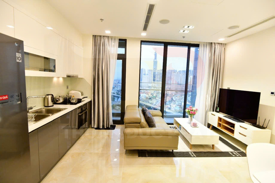 Phòng khách căn hộ hiện đại với sofa da, bếp liền kề và cửa kính lớn nhìn ra thành phố