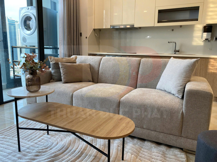Sofa vải màu be hiện đại trong phòng khách chung cư, kèm bàn trà gỗ và bình hoa trang trí