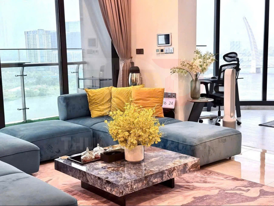 Sofa góc bọc nỉ xanh với gối tựa vàng và bàn trà đá cẩm thạch trong phòng khách view cửa kính rộng