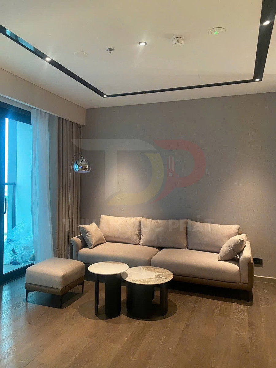 Sofa vải màu be với ghế đôn và hai bàn trà tròn mặt đá trong phòng khách hiện đại