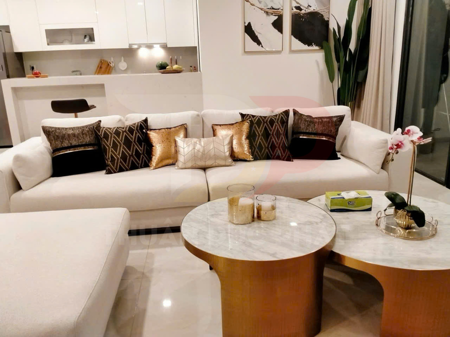 Sofa phòng khách màu trắng với nhiều gối trang trí và bàn trà mặt đá chân vàng hiện đại